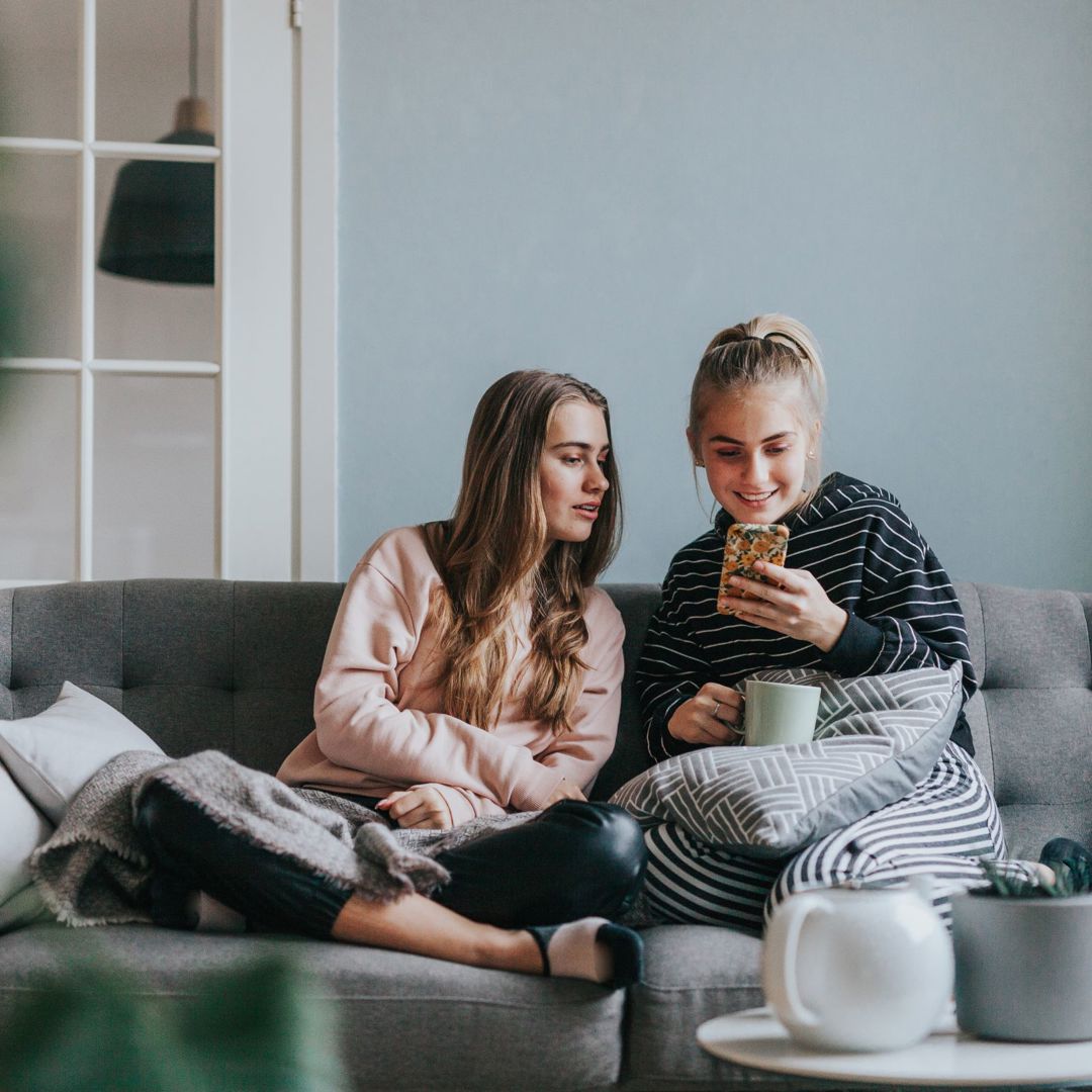 2Tienermeisjes Smartphone Tieners Grijze Zetel
