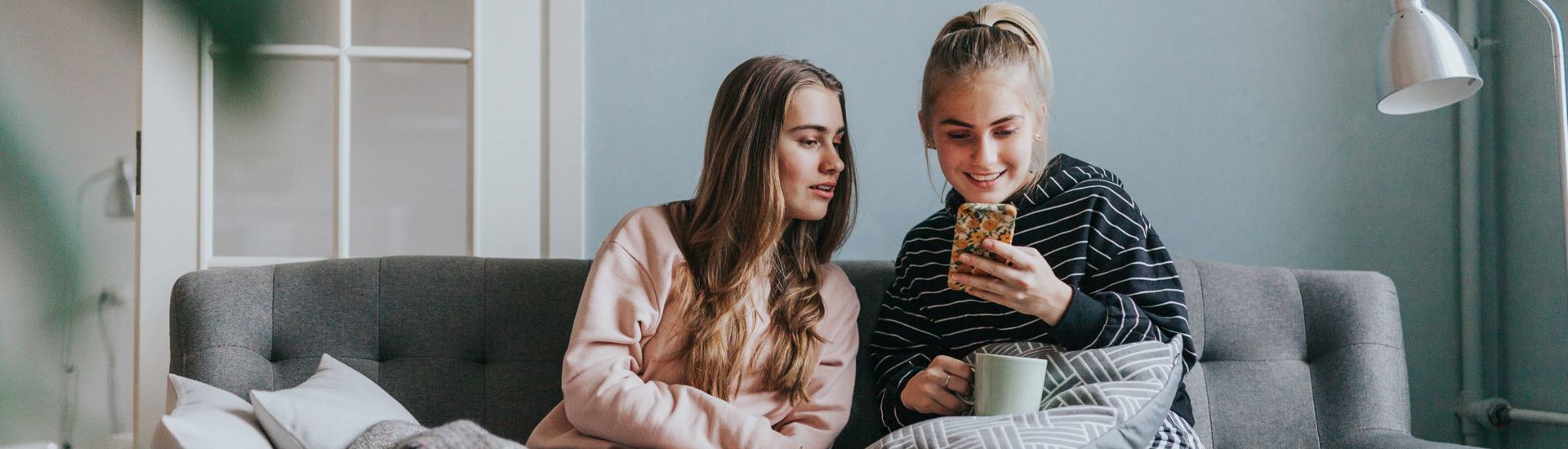2Tienermeisjes Smartphone Tieners Grijze Zetel